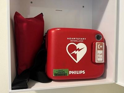 image displays an open AED cabinet with an AED inside
