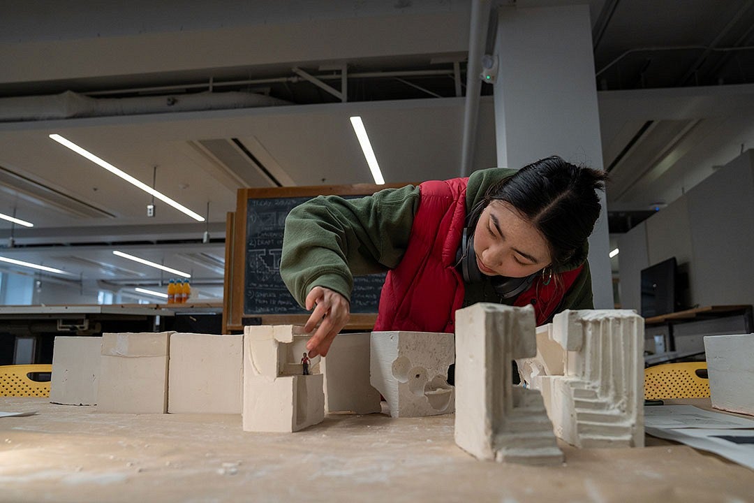 Person working with architecture models in a studio.
